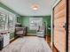 Bright Bedroom featuring wood floors, a crib, a gray armchair, and natural light at 4747 S Elati St, Englewood, CO 80110