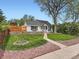 Charming single-story home featuring a well-manicured front yard, brick accents, and inviting walkway at 4747 S Elati St, Englewood, CO 80110