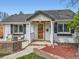 Inviting covered porch with seating area, decorative front door, and brick accents at 4747 S Elati St, Englewood, CO 80110