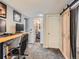 A home office featuring a desk, sliding wood door, and a view into an updated bathroom at 4747 S Elati St, Englewood, CO 80110