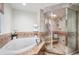Bright bathroom with a glass shower, soaker tub, and tile flooring at 5925 E Fair Ave, Centennial, CO 80111