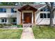 Inviting entrance with wood door, porch swing, decorative wreath and colorful flower garden at 5925 E Fair Ave, Centennial, CO 80111