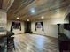 Finished basement with a stone bar, wood ceiling, wood-look flooring, and fireplace at 690 Antelope Dr, Bennett, CO 80102