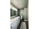 Bathroom with gray walls, wood floors, an area rug, and a marble countertop vanity at 690 Antelope Dr, Bennett, CO 80102