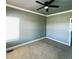 Comfortable bedroom with neutral walls and carpet and ceiling fan with dark blades at 690 Antelope Dr, Bennett, CO 80102