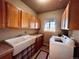This laundry room includes a sink, washing machine, dryer, and cabinets at 690 Antelope Dr, Bennett, CO 80102