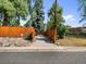 Home's gated driveway entrance with mature trees and landscaping at 4890 S Inca St, Englewood, CO 80110