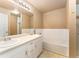 Bathroom features a double sink vanity, an oversized mirror, and a tiled tub-shower combo at 6418 Silver Mesa Dr # C, Highlands Ranch, CO 80130