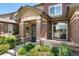 Close-up of townhome entrance with brick detail, landscaped garden, and inviting walkway at 6418 Silver Mesa Dr # C, Highlands Ranch, CO 80130
