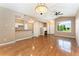 Bright open-concept living area with hardwood floors, a fireplace, and a kitchen view at 6418 Silver Mesa Dr # C, Highlands Ranch, CO 80130