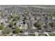 Expansive aerial view of a well-maintained neighborhood with lush green trees and manicured lawns at 13931 E 104Th Dr, Commerce City, CO 80022