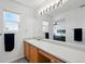 Bright bathroom features a large mirror, wood cabinets, and a view into the bedroom at 13931 E 104Th Dr, Commerce City, CO 80022