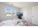 Bedroom with a picturesque view, floral bedding, and convenient TV setup at 13931 E 104Th Dr, Commerce City, CO 80022
