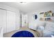 Bright bedroom features a crib, dresser, and blue rug at 13931 E 104Th Dr, Commerce City, CO 80022