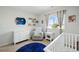 Bedroom features a comfortable glider, white crib, and cheerful decor at 13931 E 104Th Dr, Commerce City, CO 80022