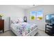 Cozy bedroom with a large window, white bed frame, and colorful floral bedding at 13931 E 104Th Dr, Commerce City, CO 80022