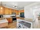 Well-lit kitchen with stainless steel appliances, wood cabinets, and a center island with seating at 13931 E 104Th Dr, Commerce City, CO 80022