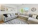 Spacious living room featuring a large sectional sofa, decorative pillows, and bright natural light at 13931 E 104Th Dr, Commerce City, CO 80022