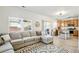 Bright living room with a comfortable sectional sofa and a view into the adjacent kitchen at 13931 E 104Th Dr, Commerce City, CO 80022