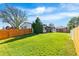 Spacious backyard with lush green lawn, wooden fence, and mature trees, perfect for outdoor activities at 6369 W 69Th Ave, Arvada, CO 80003