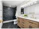 Modern bathroom with a marble tiled shower, wood vanity and gold fixtures at 6369 W 69Th Ave, Arvada, CO 80003
