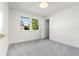 Clean bedroom with gray carpeting, white walls, and bright natural light from a large window at 6369 W 69Th Ave, Arvada, CO 80003