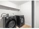 Modern laundry room featuring black Samsung washer and dryer set and wood-look floors at 6369 W 69Th Ave, Arvada, CO 80003