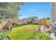 Lush backyard with green lawn, beautiful landscaping, and a stone pathway at 18096 E 104Th Way, Commerce City, CO 80022