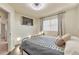 Cozy bedroom features a large window, dark wood floors and a comfortable queen bed at 18096 E 104Th Way, Commerce City, CO 80022