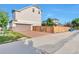 Tan two-story home featuring an attached garage and brick paved driveway, complemented by a wood fence at 18096 E 104Th Way, Commerce City, CO 80022