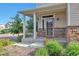 Charming front porch with stone accents and decorative railing detail, surrounded by lush greenery at 18096 E 104Th Way, Commerce City, CO 80022
