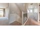 Well-lit hallway with carpet flooring, staircase, and neutral wall paint at 18096 E 104Th Way, Commerce City, CO 80022