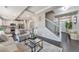 Open-concept living room flowing into the kitchen, with a modern staircase and stylish furnishings at 18096 E 104Th Way, Commerce City, CO 80022