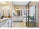 This luxurious bathroom has double sinks, a soaking tub, glass-enclosed shower, and tile flooring at 7743 S Quantock Way, Aurora, CO 80016