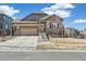 Lovely home with a neatly maintained lawn, complemented by stone accents and a welcoming front entrance on a sunny day at 7743 S Quantock Way, Aurora, CO 80016