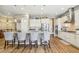 Bright kitchen featuring a spacious island with bar seating, complemented by stainless steel appliances and elegant white cabinets at 7743 S Quantock Way, Aurora, CO 80016