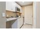 This kitchenette features granite countertops, white cabinets, stainless appliances, and a convenient sink at 7743 S Quantock Way, Aurora, CO 80016