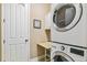 Functional laundry room with stacked washer and dryer and a folding table at 7743 S Quantock Way, Aurora, CO 80016