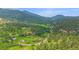 Panoramic aerial view showcasing a scenic property with lush landscapes and a winding road through the mountains at 9745 Hilldale Dr, Morrison, CO 80465