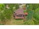 Aerial view featuring a wooden home with an extensive deck, surrounded by tall trees and a well-kept yard at 9745 Hilldale Dr, Morrison, CO 80465