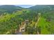 Aerial shot of a charming home nestled in a lush forest, showcasing its driveway and surrounding greenery at 9745 Hilldale Dr, Morrison, CO 80465