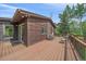 Exterior view of a wood sided home with sliding glass doors leading to a wooden deck at 9745 Hilldale Dr, Morrison, CO 80465