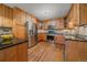 Well-lit kitchen boasts stainless steel appliances, natural wood cabinets, and black granite countertops at 9745 Hilldale Dr, Morrison, CO 80465