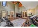 Spacious living room featuring a wood-burning fireplace, clerestory windows, and comfortable leather seating at 9745 Hilldale Dr, Morrison, CO 80465