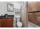 Well-lit bathroom featuring a toilet, sink, and bathtub with shower curtain at 1717 E 22Nd Ave, Denver, CO 80205