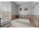 Relaxing bathroom featuring a large soaking tub with tiled surround and a window at 1717 E 22Nd Ave, Denver, CO 80205