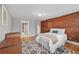 Bedroom featuring an exposed brick wall, hardwood floors, and ensuite bathroom at 1717 E 22Nd Ave, Denver, CO 80205