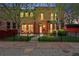 Charming brick home with black fence, red accents, small front yard, and mature trees at 1717 E 22Nd Ave, Denver, CO 80205