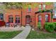 Charming brick home with vibrant red trim, inviting front porch, and well-manicured landscaping at 1717 E 22Nd Ave, Denver, CO 80205