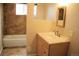 Bathroom features a vanity with cultured marble countertop, a mirror, and a bathtub with shower at 1212 N County Road 125, Bennett, CO 80102